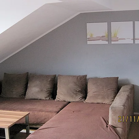 Ferienhaus Renate, Wohnzimmer mit brauner Couch und Holztisch