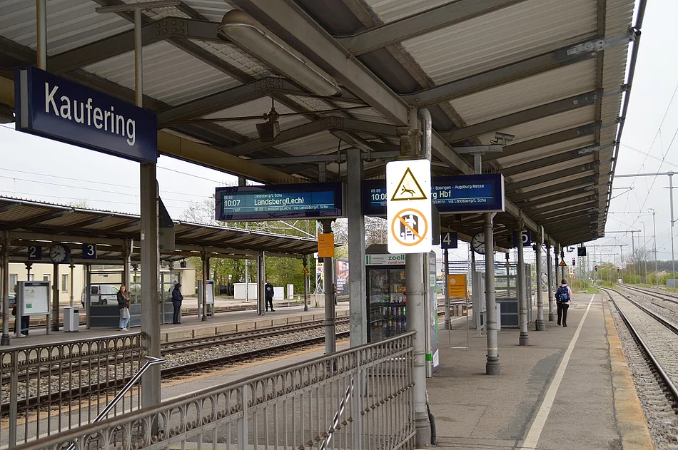 Bahnsteig mit Überdachung, Fahrgastinformationsanzeigen und Schild mit dem Stationsnamen Kaufering
